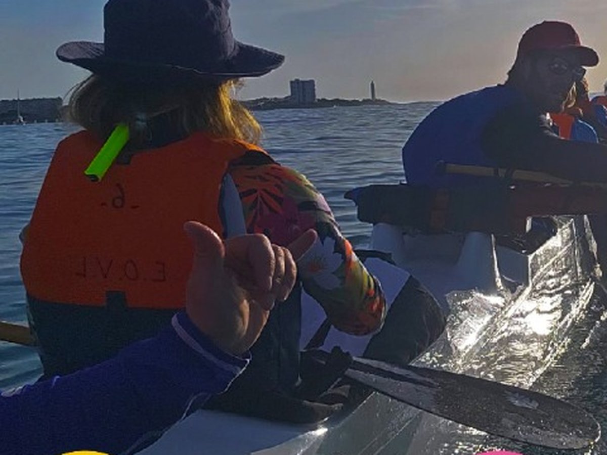 Équipage pagayant en pirogue polynésienne au coucher du soleil au large des Sables d'Olonne